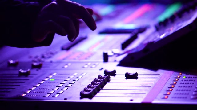 Close-up in motion of sound engineer working on his workplace