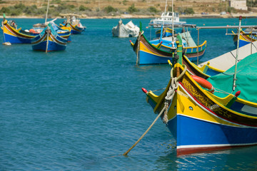 Fototapeta na wymiar Colorful, old fisher boats are parking in harbor of Marsaxlokk, Malta