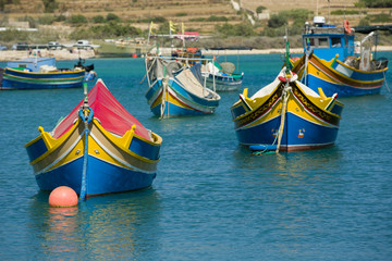 Colorful, old fisher boats are parking in harbor of Marsaxlokk, Malta