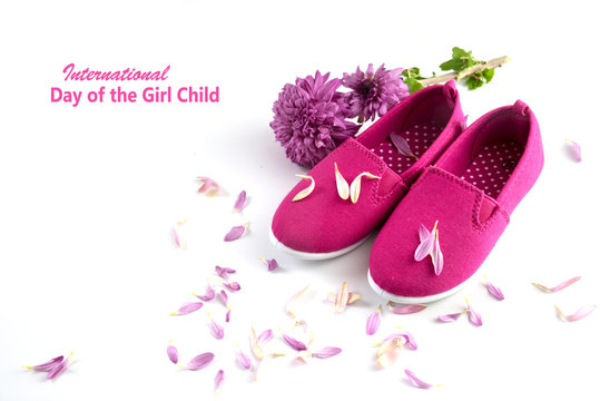 pink kid shoes, flower and petals isolated on a white background, text International Day of the Girl Child, concept date 11 Octobe