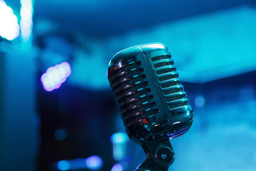Fototapeta na wymiar Retro microphone against blur colorful light restaurant background
