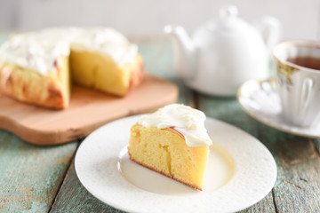 Homemade rustic cake with whipped cream and black tea on shabby blue table