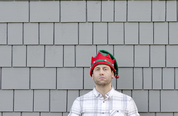 Lack of Christmas cheer. Man in a Christmas hat with no expression.