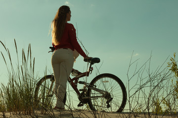 Unrecognizable woman bike cycling on sand