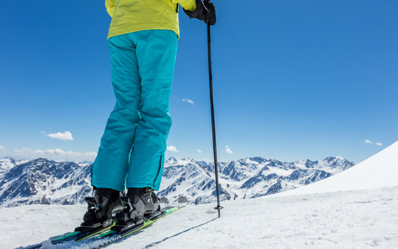 Detail of legs of young woman skier in beautiful Alpine landscape