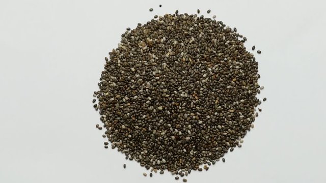 Chia seeds rotating on white background. Close up
