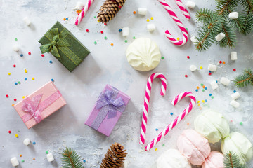 Christmas background with a present and festive decorations on a stone background. Top view.