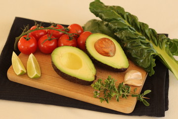 Avocado cut in half witch vegetables (garlic, herbs, tomatoes, lime and spinach)