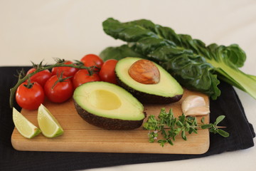 Avocado cut in half witch vegetables (garlic, herbs, tomatoes, lime and spinach)