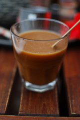 Glass of vietnamese milk coffee isolated on rustic background close up view.