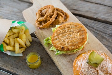 High angle view of burger with onion rings and french fries on