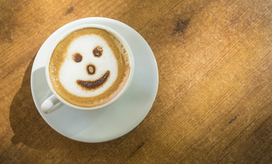 Cup of hot cappuccino coffee on wooden table.