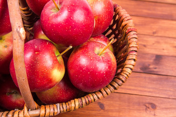 Basket full of apples on a wooden background