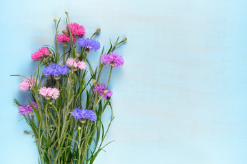 Cornflowers on blue wooden background