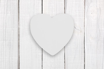 Blank white wooden heart on white wooden background