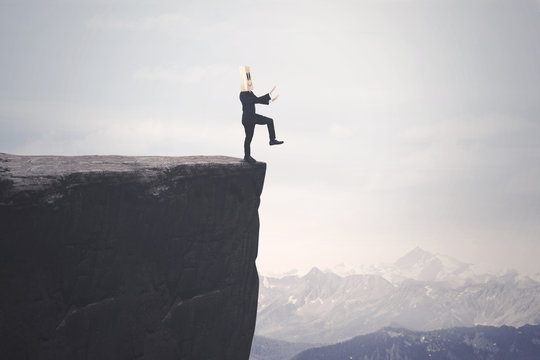 Disoriented businessman walks on the cliff