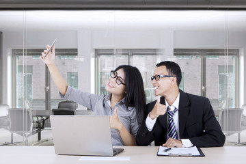 Businesswoman taking selfie with partner