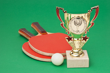 sports awards and  tennis racquets on  green table