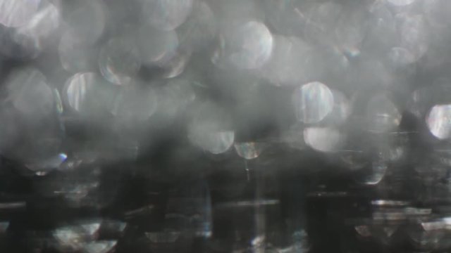 The Circles Bokeh stock video features a circle rotation in a clockwise direction of grey blurred lights. You can use it as an overlay for creative video effects, artistic videos, and as a texture by
