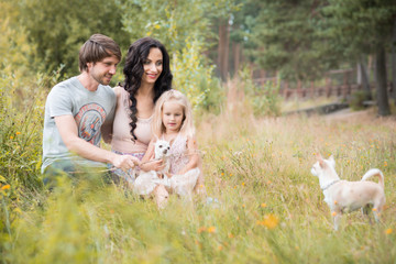 Fototapeta premium Beautiful young family with two daughters walking in the forest in summer