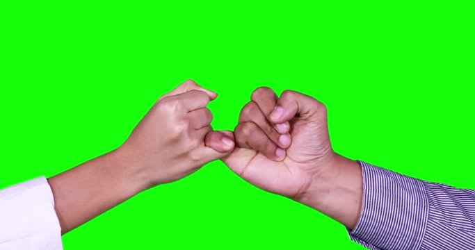 Two anonymous people hands making a pinkie promise in front of green screen background. Shot in 4k resolution