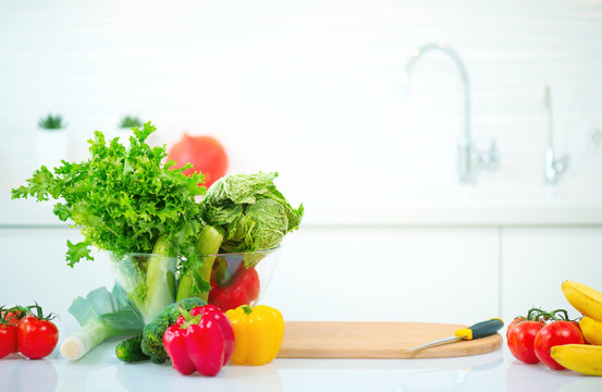 Fototapeta Kitchen table with fresh organic vegetables and fruits. Healthy eating concept