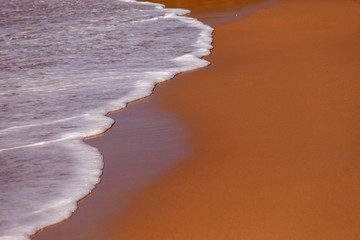 Wave of blue ocean on sandy beach. Background.