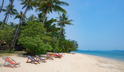 Beach chairs on idyllic tropical sand beach.