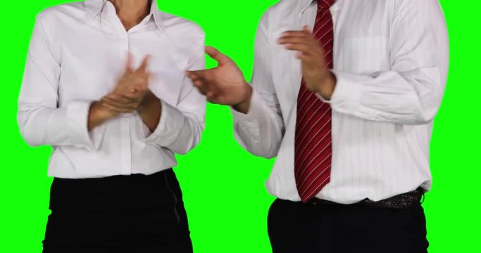 Two unrecognizable business team applauding together while standing in the studio with green screen background. Shot in 4k resolution