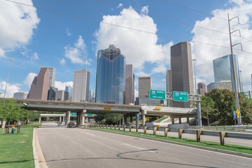 Downtown Houston from Allen Parkway near Sabine street under cloud blue sky. Highway/expressway in...