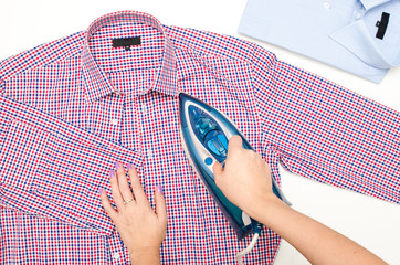 Female hand ironing men's shirt