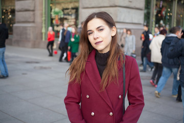 a woman stands on a busy street and looking at the camera