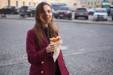 the girl on the street holding a cakes and laughs