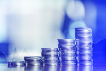 Double exposure Stacks of coins on working table with financial graph chart, finance and business...