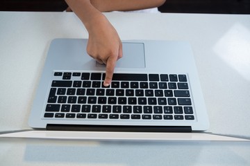 Fototapeta na wymiar High angle view of girl pressing key on laptop