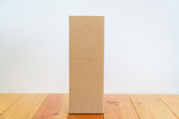 Empty Package brown cardboard box for long items on wooden table with copy space.