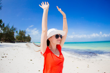Happy woman in hat on tropical beach enjoy her vacation