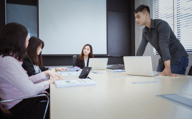 Asian businessmen and group using notebook for business partners discussing documents and ideas at meeting and business women serious about the work