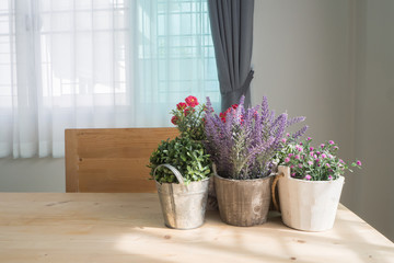 wood table with copy space and group of beautiful artificial flower on pot at living room.