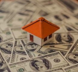 House from the paper and money on wooden background