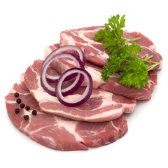 Raw pork neck chop meat with parsley herb leaves, peppercorn spices and onion slices garnish isolated on white background cutout