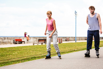 Fototapeta premium Friends rollerblading together have fun in park.