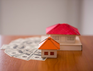 building, mortgage, investment, real estate and property concept - close up of home or house model...