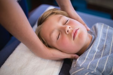 Obraz na płótnie Canvas High angle view of boy with eyes closed receiving neck massage
