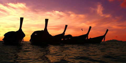 long tail boat, in white sand beach in  andaman sea at sunset time