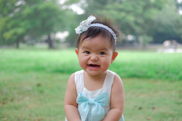 Asian Adorable baby girl playing in park. Beautiful smiling cute baby