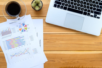 Office desk table with laptop, cup of coffee and financial report.Top view with copy space.Working desk table concept.