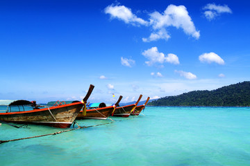 long tail boat, in white sand beach in  andaman sea