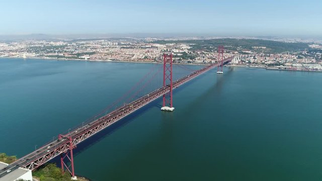 Aerial static footage of 25 de Abril Bridge in Portuguese Ponte 25 de Abril is suspension bridge connecting city of Lisbon capital of Portugal to municipality of Almada on left bank of Tagus river 4k