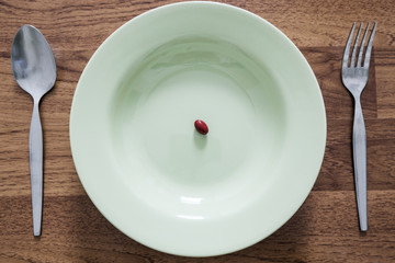 Supplementary food on the dish with fork and spoon on white table